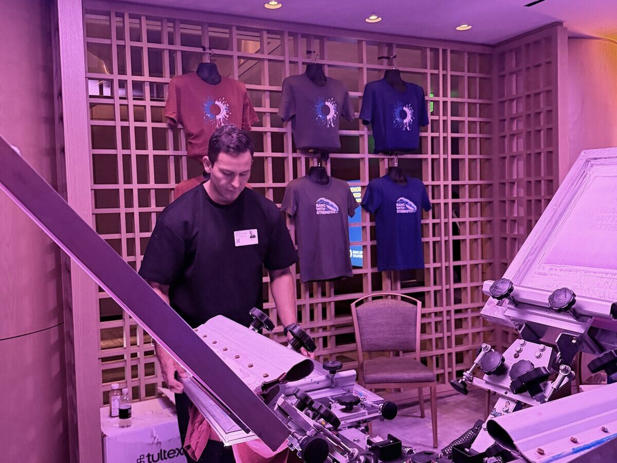 Shirt bar press station with a stack of finished custom tees